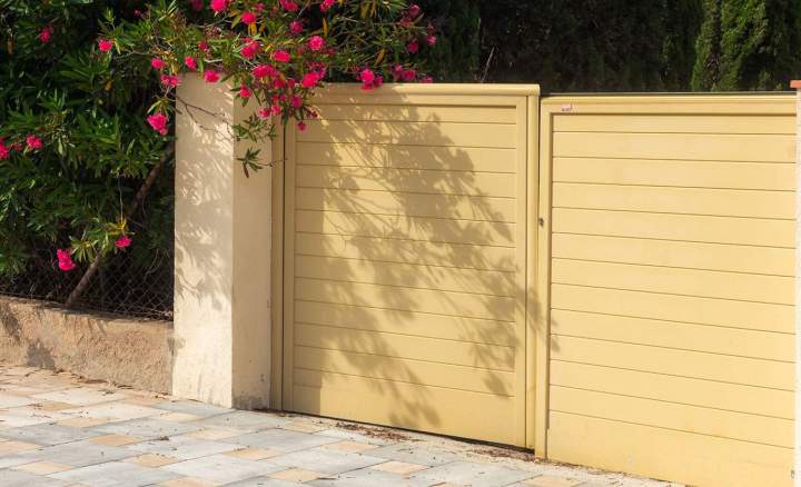 Portail plein à lames horizontales en aluminium, coloris sable, avec panneau de clôture assorti et pilier enduit